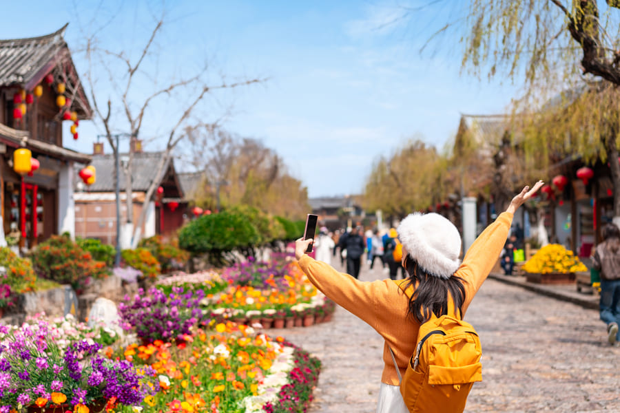 Mujer en la calle de Yunnan con los brazos abierto y hacia arriba